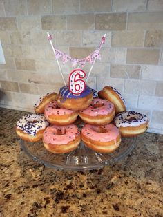 a cake made out of doughnuts and sprinkles on a glass platter