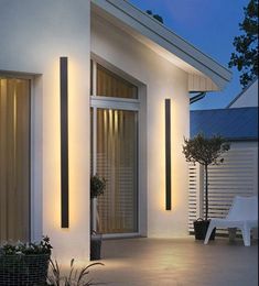 an outdoor area with lights on the side of it and plants in pots next to them