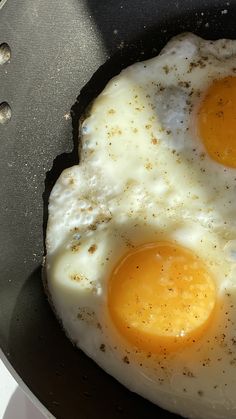 two fried eggs in a frying pan on the stove