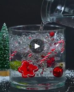 water being poured into a glass filled with candy canes and peppermint ornaments