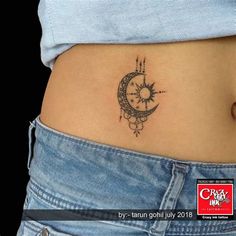 a woman's stomach with a small tattoo on the side of her belly, which has a sun and moon in it