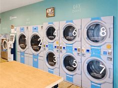 a row of washers sitting next to each other in a laundment room