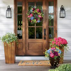 two flower pots sitting in front of a wooden door