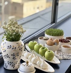 an assortment of fruits and vegetables are displayed on a window sill