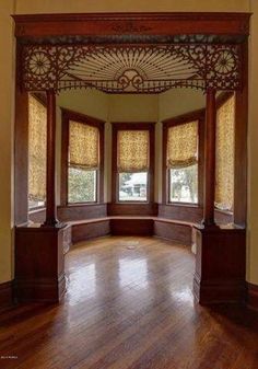 an empty room with wooden floors and windows