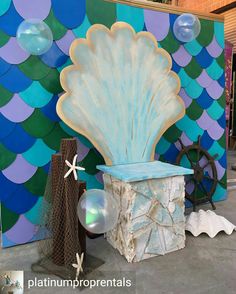 there is a large shell on display in front of a wall with blue and green colors