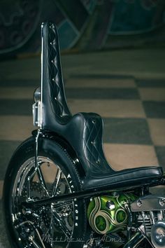 a black motorcycle parked on top of a checkered floor