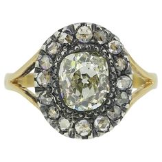 Here we have a beautifully assembled diamond cluster ring dating back to the Victorian period. A single oval shaped old mine cut diamond sits proud at the centre of the face in a silver collet setting. This chunky principle stone is then framed by a circulating array of tiny rose cut diamonds around the outer edge in a single line formation before the piece is finished with open split shoulders and an otherwise plain polished band. This piece started life as a stick pin but has been experty transformed into a more practical everyday ring by master antique jewellery re-designer and restorer, Gaetano Chiavetta. Condition: Used (Very Good) Weight: 2.7 grams Size: J (49) Band Width: 2mm Face Dimensions: 12mm Centre Diamond Weight: Approx. 1.16ct Diamond Details: Colour: L, Clarity: SI Rose Cut Oval Cluster Ring With Single Cut Diamonds, Antique Cushion Cut Single Diamond Rings, Antique Cushion Cut Ring With Single Cut Diamonds, Antique Cushion Cut Rings With Single Cut Diamonds, Oval Diamond White Cluster Ring With Single Cut Diamonds, Oval Cluster Ring With Single Cut Diamonds In White, Victorian Oval Diamond Ring With Rose Cut Diamonds, Vintage Diamond Ring With Rose And Cushion Cut, Vintage Cushion Cut Diamond Ring With Rose Cut Diamonds