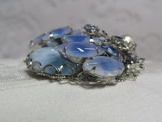 This is a lovely vintage light blue art glass brooch in the style of Alice Caviness. All stones are intact and have a rich color. There are no scratches on the faux pearl bead and the silver finish is untarnished. The clasp is secure. Light Blue Art, Filigree Pendant Necklace, Filigree Pendant, Blue Art, Pearl Beads, Vintage Gold, Rich Color, Art Glass, Faux Pearl