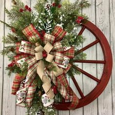 a christmas wreath on top of a wagon wheel