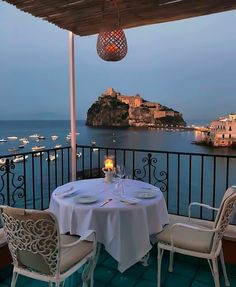 an outdoor dining area overlooking the ocean and town