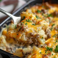 a spoon full of cheesy casserole with meat and cheese