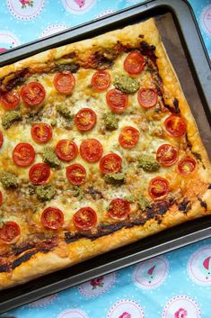 a square pizza with tomatoes and broccoli on it