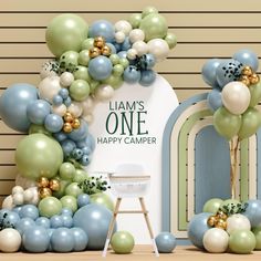 an arch made out of balloons and greenery with the words i am's one happy camper on it