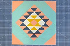 a quilter's block with an orange and blue design