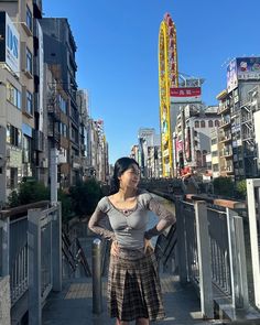 a woman is standing on a bridge with her hands on her hips and looking at the camera