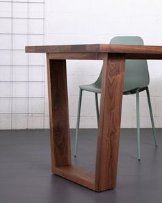 a wooden table sitting next to a green chair