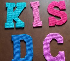 the letters are made out of knitted material and placed on a brown table top