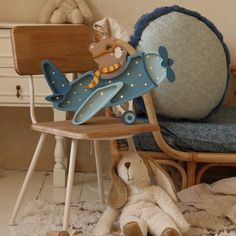 a stuffed animal sitting on top of a wooden chair next to a teddy bear in a rocking chair