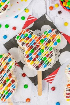 an ice cream sundae is on a plate with candy and candies around it