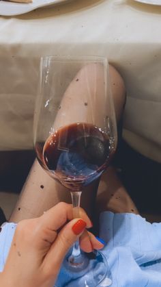 a woman holding a wine glass in her hand