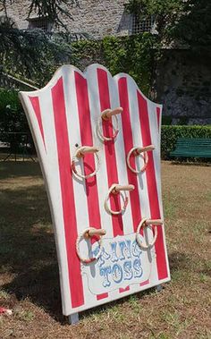 a large red and white striped sign sitting on top of a grass covered park bench