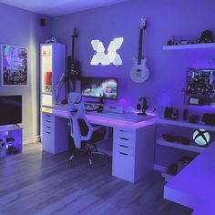 a room with purple lighting and various items on the desk, including a computer monitor