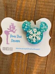 a disney mouse ear with snowflakes on it and a name tag attached to it