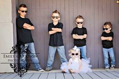 a group of young children standing next to each other in front of a wooden wall