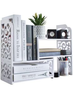 a white book shelf with books on top of it and a potted plant in the corner