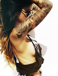 a woman with tattoos on her arm and chest