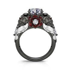 a black and white ring with red flowers on the side, surrounded by three diamonds