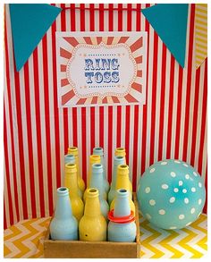 a table topped with blue and yellow bottles next to an orange striped box filled with beer