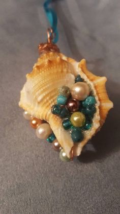 a sea shell with pearls and other beads