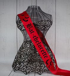 a red ribbon with the words happy halloween on it sitting next to a mannequin