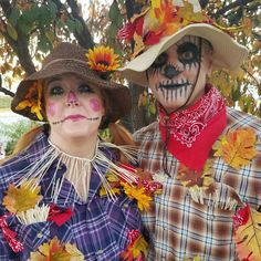 two people dressed up in costumes with leaves around their necks and face painted like sunflowers