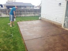 a man is using a pressure washer to clean the concrete in his backyard area