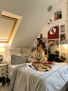 a woman sitting on top of a bed in a bedroom