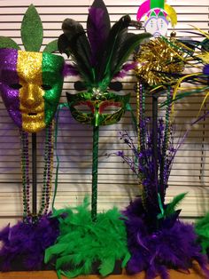 three mardi gras masks are sitting on top of each other in front of a window