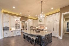 a large kitchen with an island in the middle and lots of cabinets on both sides