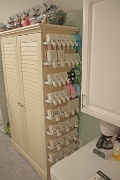 a white cabinet filled with lots of cups and saucers