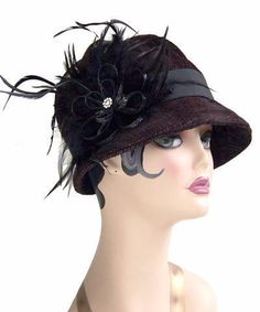 THE GRACE, handmade in Seattle, WA, USA, is a soft and flexible, 1920s style cloche hat. This hat is shown in Bongo Black/Gray Upholstery Fabric with assorted bands and trims. The brim is 2" at center front, flaring out to 2 3/4" at side front, and curving back to 3/4" at center back of hat. The crown is made of six panels. Prices are as shown. May be ordered without band for $79. These hats are custom made and all sales are final. Available in Medium 22-1/2 " and Large 23-1/2 " with custom sizi Elegant Black Bucket Hat, Elegant Black Bucket Hat With Short Brim, Fitted Flapper Cloche Hat With Brim, Fitted Flapper Cloche Hat, Elegant Black Adjustable Bucket Hat, Elegant Adjustable Black Bucket Hat, Adjustable Cloche Hat In Flapper Style, Adjustable Cloche Flapper Hat, Gatsby Style Short Brim Cloche Hat For Party