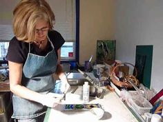 a woman in an apron is painting on a table