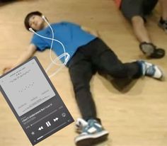 a man is laying on the floor with headphones in his ears and listening to music