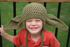 a young boy wearing a crocheted yoda hat