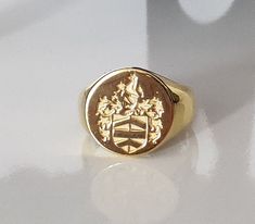 WELCOME TO CUSTOMRING BYELIF A family crest, emblem, or logo will be added to your bespoke signet ring to make it uniquely yours. It is genuine 925 sterling silver and unisex. The rings can be gold filled with 24k gold. Name engravings are one option for vintage bespoke signet rings. It makes the ideal gift for family members who appreciate antique jewelry and vintage rings. Create your own unique ring, and solid gold alternatives can include a family crest. PRODUCTS IN INVENTORY Sterling Silver Gold Engraved Ring With Coat Of Arms For Anniversary, Classic Signet Ring With Coat Of Arms For Anniversary, Classic Oval Signet Ring With Coat Of Arms, Classic Personalized Signet Ring For Commemoration, Personalized Classic Signet Ring For Commemoration, Classic Coat Of Arms Ring, Heirloom Signet Ring With Coat Of Arms, Gold Signet Ring With Coat Of Arms, Heirloom Coat Of Arms Jewelry For Anniversary