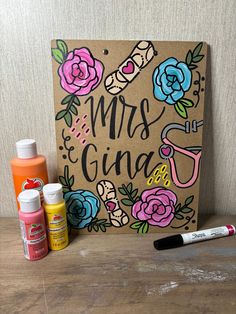 some crafting supplies sitting on top of a wooden table next to a paper bag