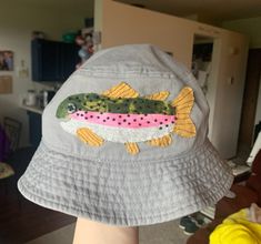 a person wearing a hat with a fish embroidered on it