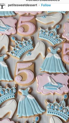 some decorated cookies are sitting on a table with blue and pink frosted icing