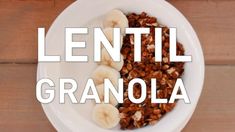 a white bowl filled with granola and sliced bananas on top of a wooden table